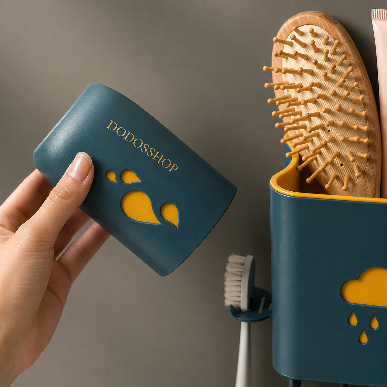 Bathroom Storage Rack
A hand holds a dark teal toothbrush holder with gold 'DODOSSHOP' branding and yellow cloud-shaped cutouts. To the right, a matching holder on a wall mount holds a wooden hairbrush and a white toothbrush.