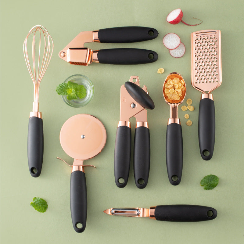 Elegant Stainless Steel Kitchen Tool Set
Set of kitchen utensils with rose gold and black handles on a green background