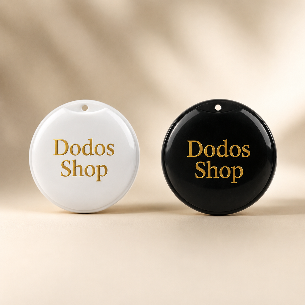 GPS Pet Tracker
Two round, glossy keepsake boxes or ornaments in white and black, both featuring the words 'Dodos Shop' in gold serif lettering, set against a warm beige background with soft leaf shadows.