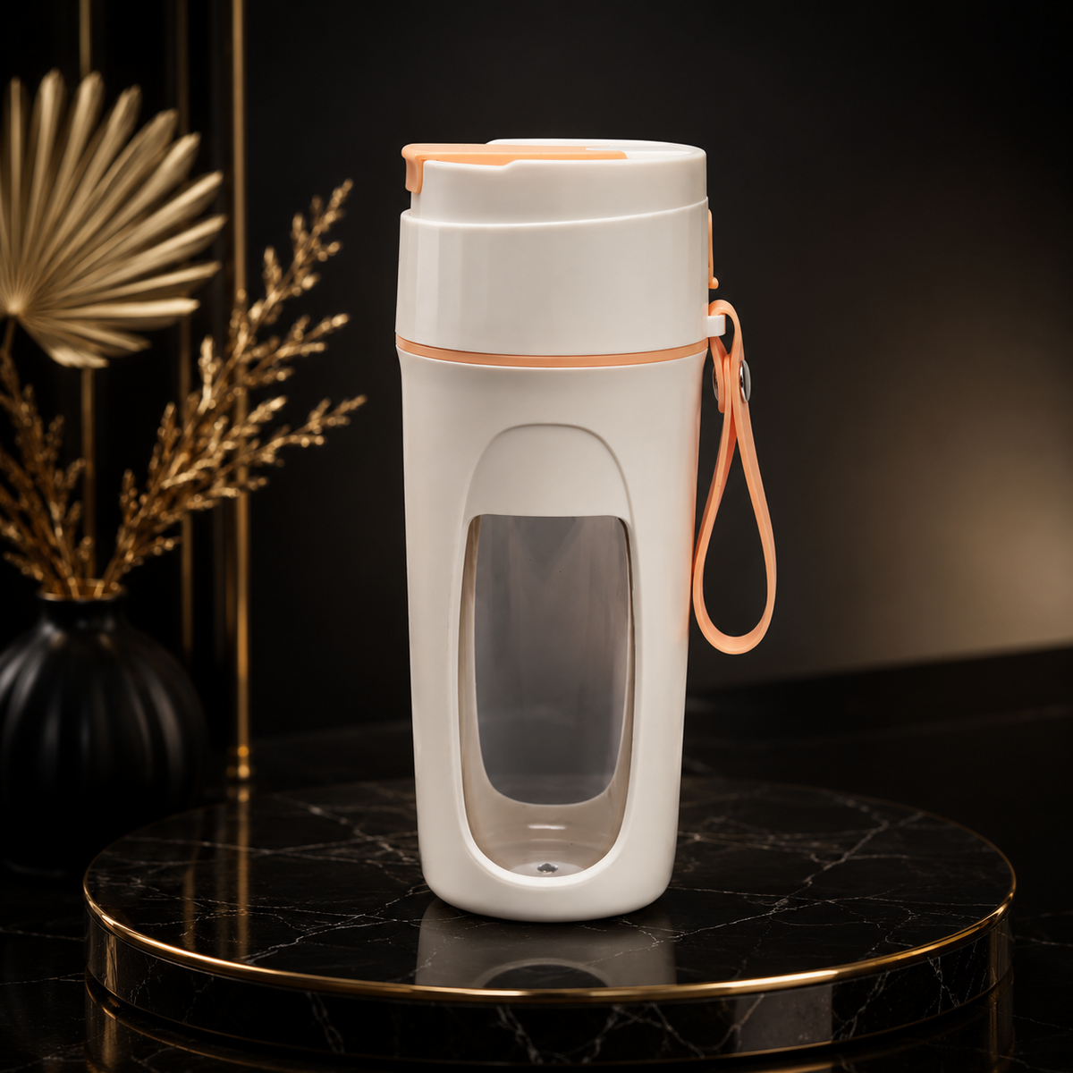 Portable USB Blender
A tall white travel tumbler with a clear window and peach-colored accents, including a matching wrist strap, displayed on a black marble pedestal against a dark background.