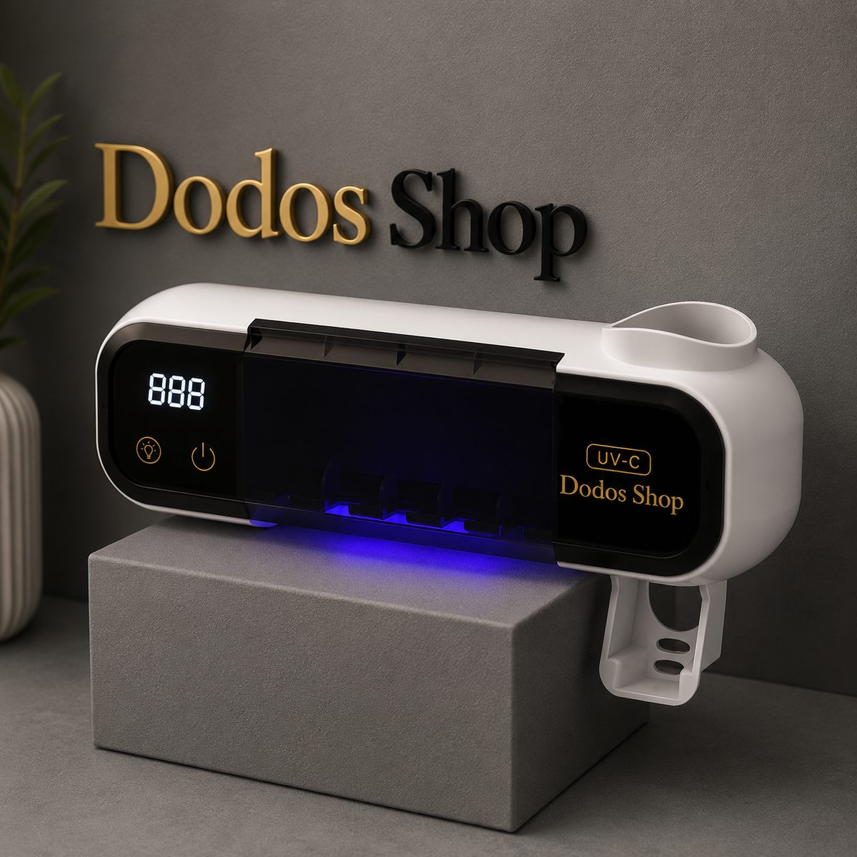 A white and black UV-C lamp holder or sanitizer station with a digital display and blue light glow, shown resting on a gray block against a dark gray wall with 'Dodos Shop' branding.