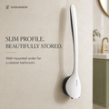 A wall-mounted white and black shower head holder with a slim profile, shown mounted on a beige marble bathroom wall. Text on the left reads 'SLIM PROFILE.